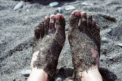 Feet in pebbles on the beach