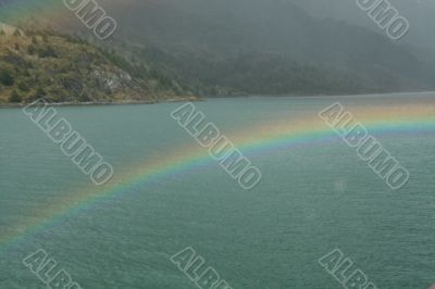 Rainbow, rocky hills and glacier