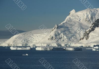 Icebergs, mountains, clear blue sky