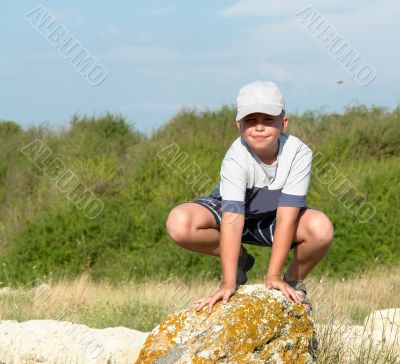 boy sitting on a rock