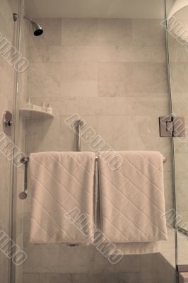White Towels on Rack on Wet Glass Shower Door