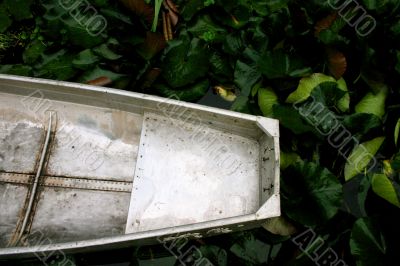 Aluminum canoe resting amidst waterlilies