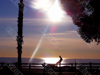 Silhouette of man by the sea at sunset