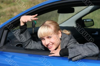 Young woman in a car with key