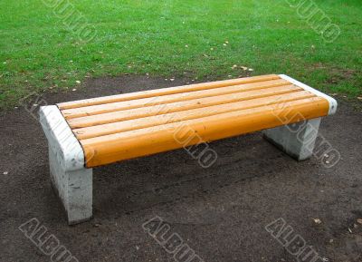 yellow bench in park after rain
