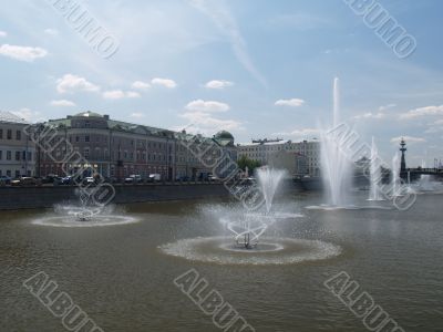 Fountains on the river in summer day