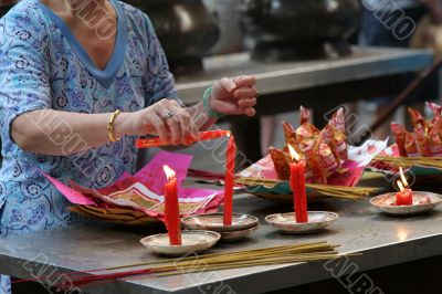 Woman in temple lighting a candle