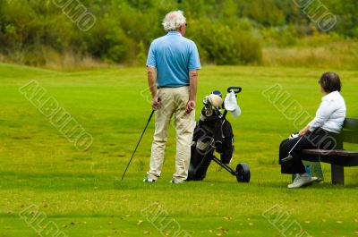 senior couple playing golf