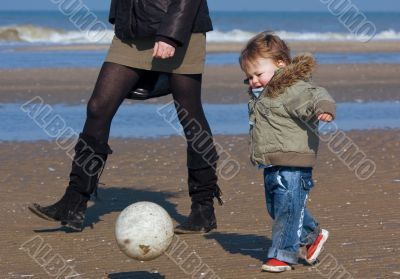 boy playing soccer on the beach