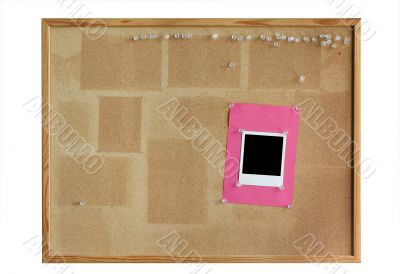 cork board with empty photo frame