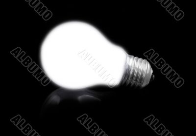 close-up of lit light bulb on black