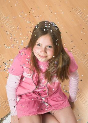Girl covered in confetti on the floor