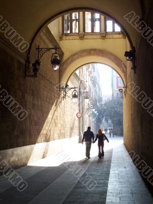 two enamoured in a Barcelonian arch