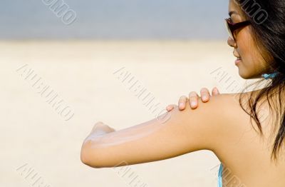 Applying Suncream At Beach
