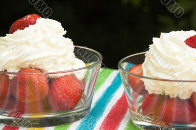 Two bowls with strawberries and cream