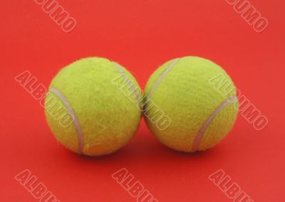 two tennis balls on red