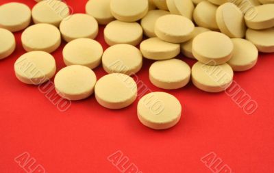 handful of yellow tablets on red