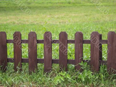 Wooden fence on green grass