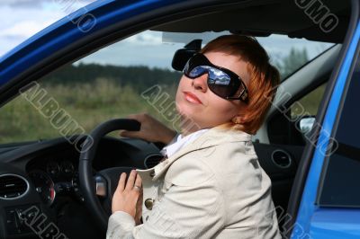 Red-haired woman in a blue car