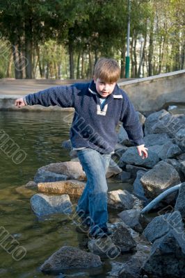 boy on stones near water