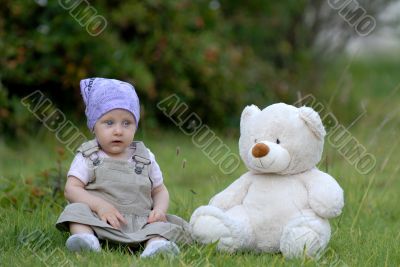 baby on the grass with a bear toy