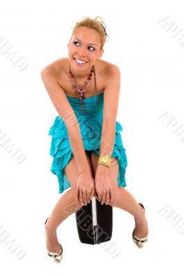 Beautiful blond sitting on a suitcase