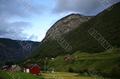 Rural landscape with mountain, field and houses