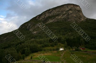 Rural landscape with mountain, field and houses