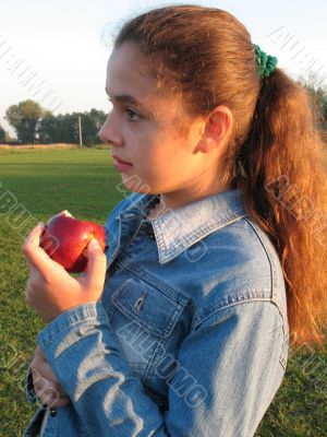 Girl with an apple on a feild