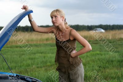 young blond woman with her broken car.