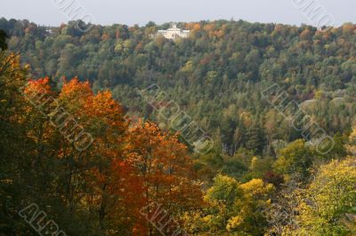 Colorful autumn forrest with white villa