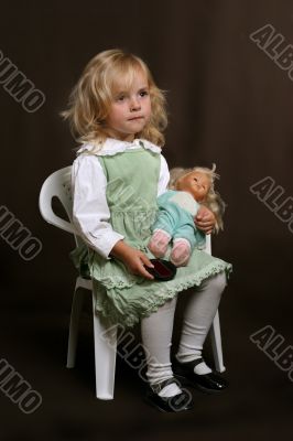 cute little girl in green dress with doll