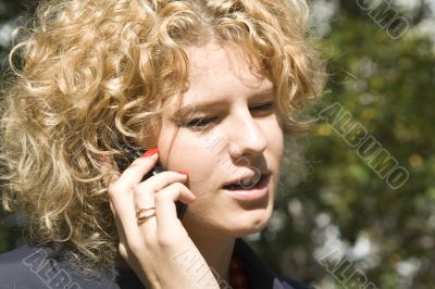 The business woman talks by a mobile phone