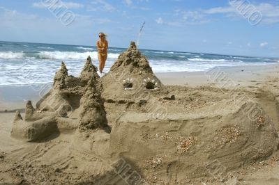 sand castle with a girl in background