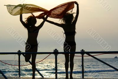 silhouettes of two girls dancing with scarfs