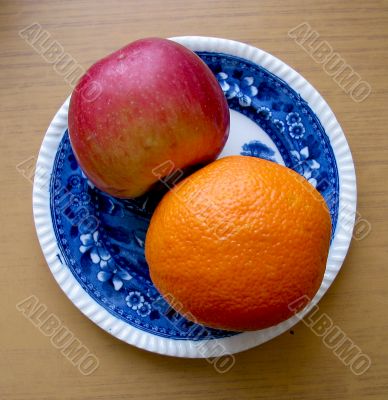 Apple and orange in blue plate