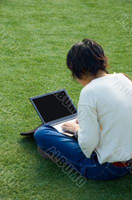 Girl on the grass with a laptop