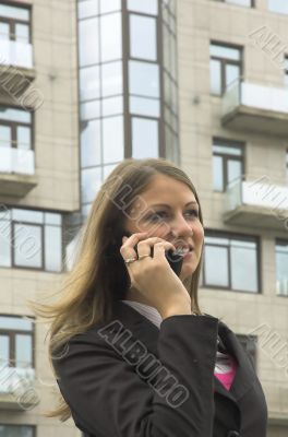 The young woman speaks by phone in the street