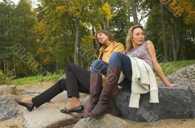 Two girls having a rest in autumn park