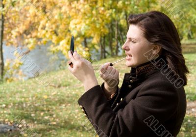 woman put on lipstick.