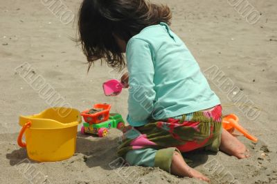 Little girl, sand and toys