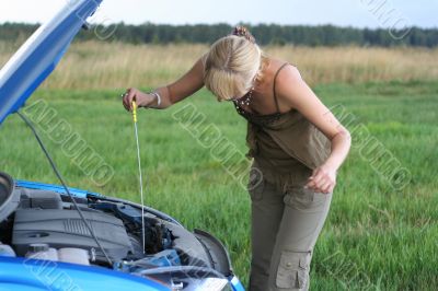 young blond woman with her broken car. The girl is sad