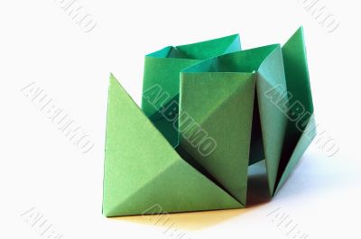 Green paper toy-ship on a white background.
