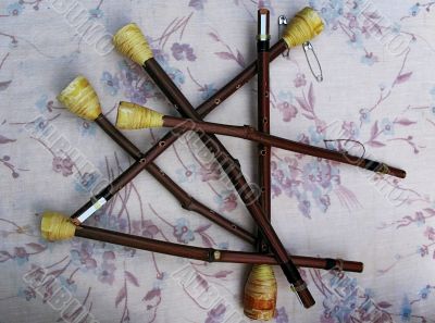 wooden flutes resting upon fabrics