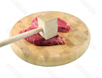Steaks on a chopping board with Mallet