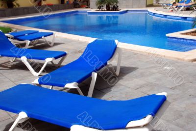 pool with blue chairs around it