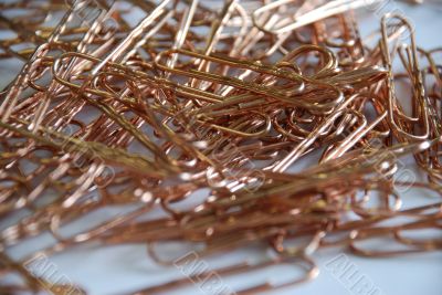 Copper paper clips lay on a table