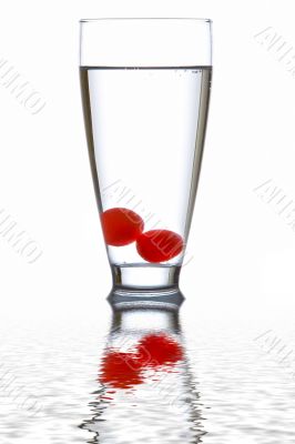 Glass of fresh water with cherries