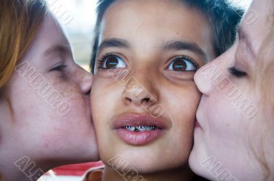 girls kissing boy