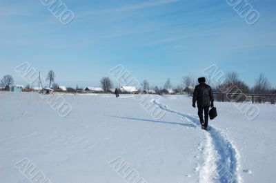 A man with a brief case, returning from the city to his village